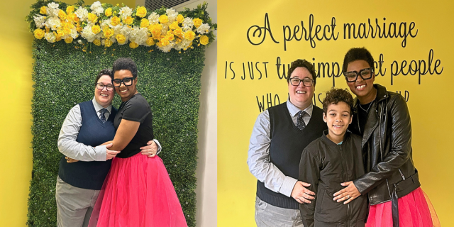 The author (a black woman with short hair) and her wife (a white butch with brown hair) pose against a yellow and green wall on their wedding day with their son.