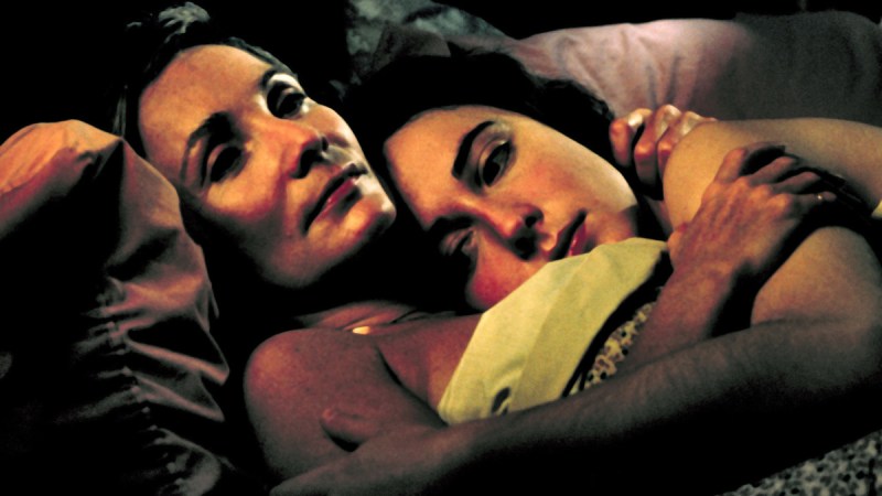 A couple holds each other in bed in Lillianna