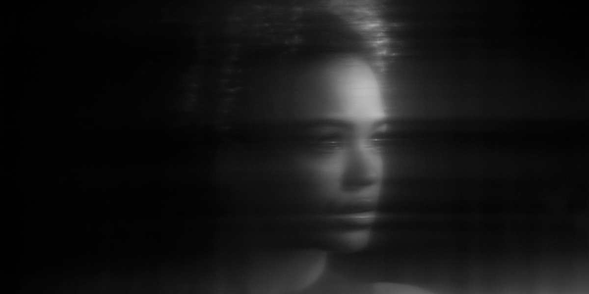 a woman blurred in darkness