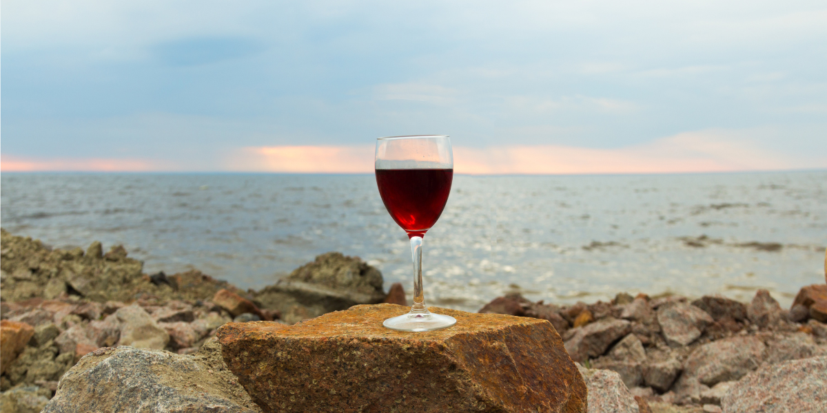 a glass of red wine on a rock