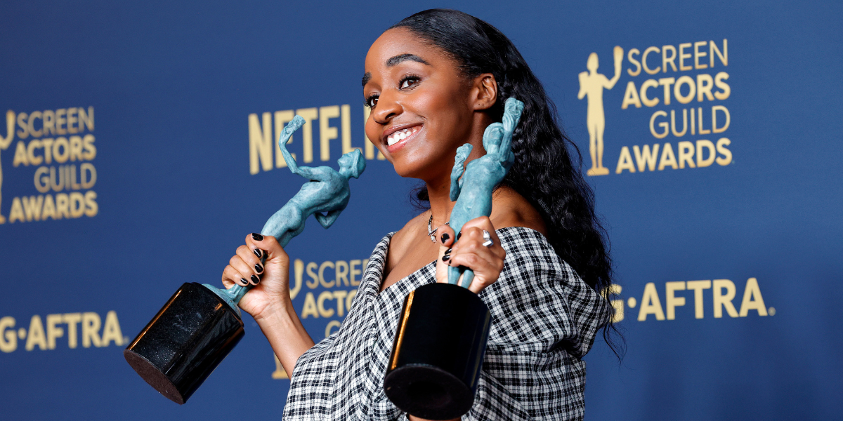 Ayo Edebiri holding SAG awards on a red carpet