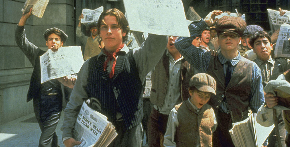 still of newsies in the movie newsies, holding up their papers