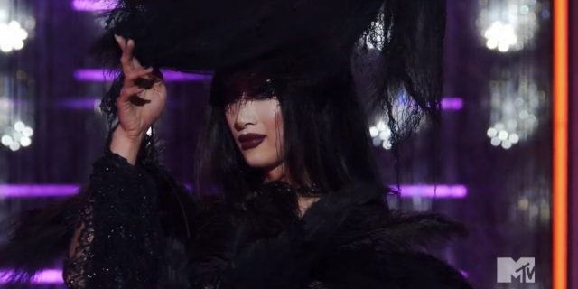 Drag Race 1609: Nymphia looks out from under the veil of her goth look
