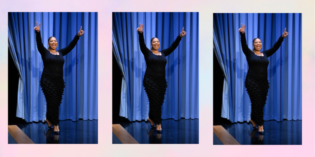Queen Latifah throwing up double peace signs with a blue curtain behind her on the Tonight Show