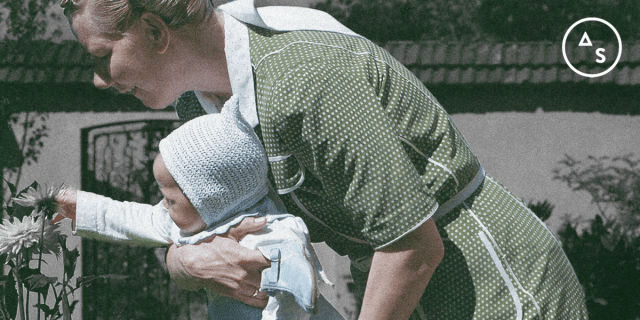 A grainy portion of a still from The Zone of Interest with Sandra Hüller holding a baby.