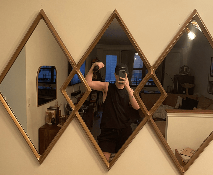 The author Motti flexing in a black tank in a mirror selfie