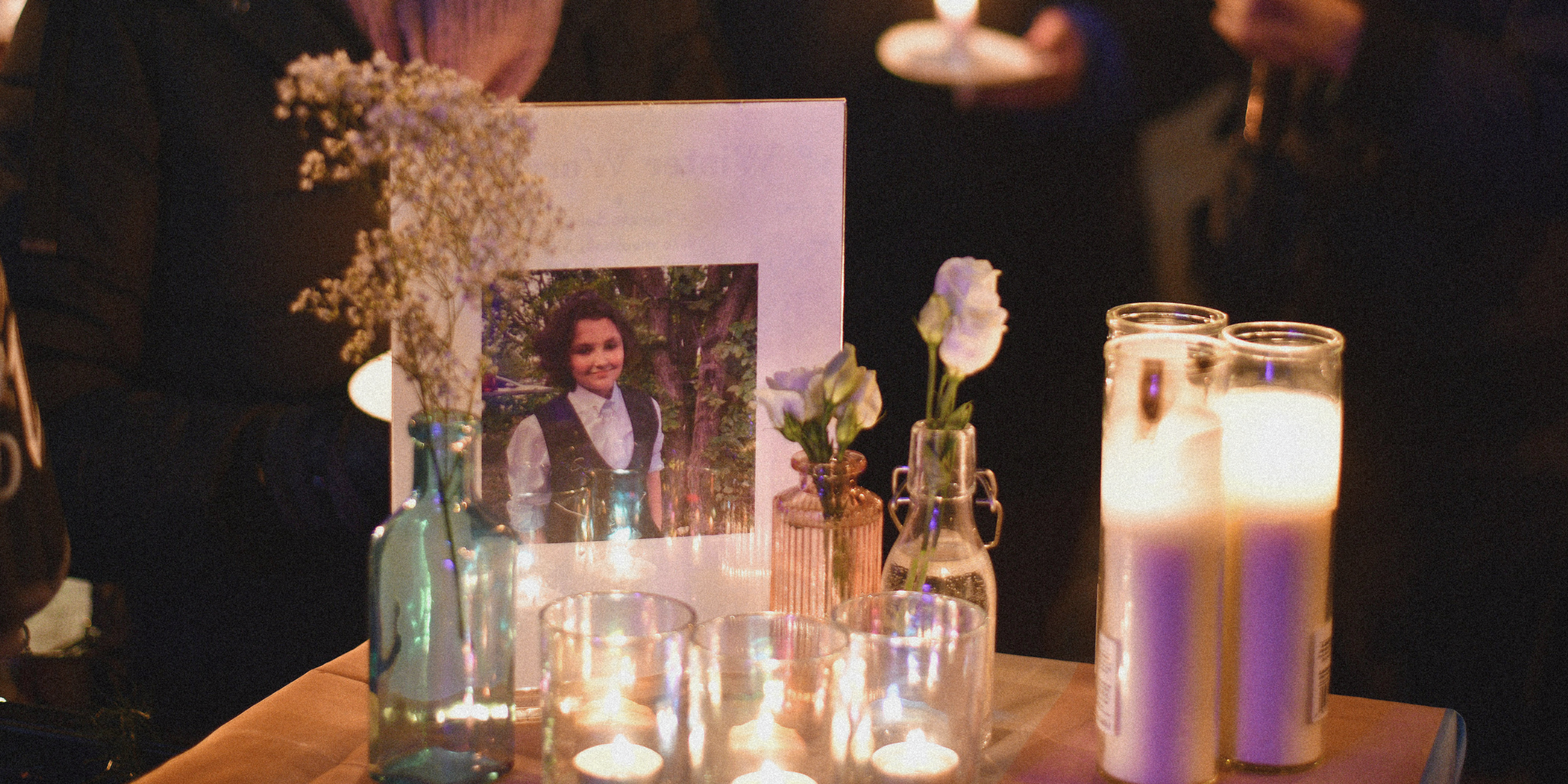 A vigil for Nex Benedict shows his photo next to candles