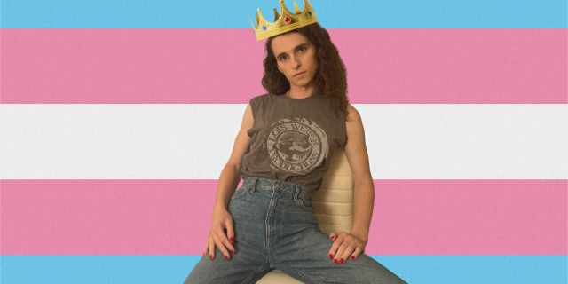 Drew wearing a crown with a trans flag behind her