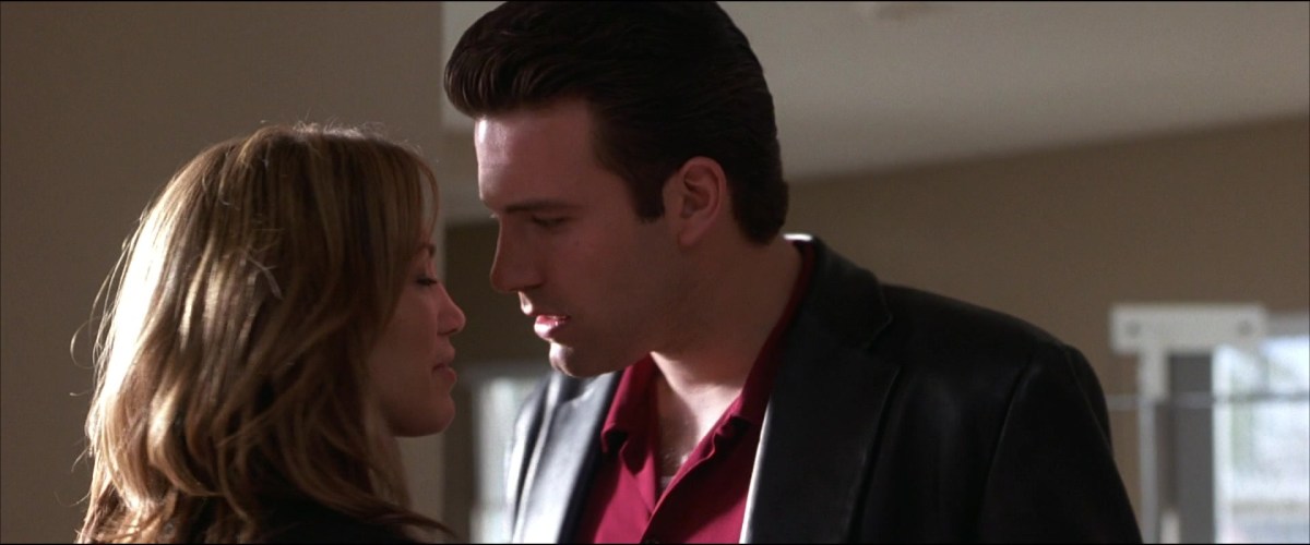 Jennifer Lopez and Ben Affleck standing with their faces close together in Gigli