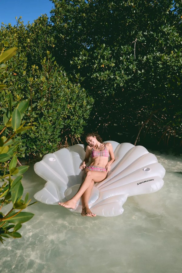 a woman in a seashell pool float