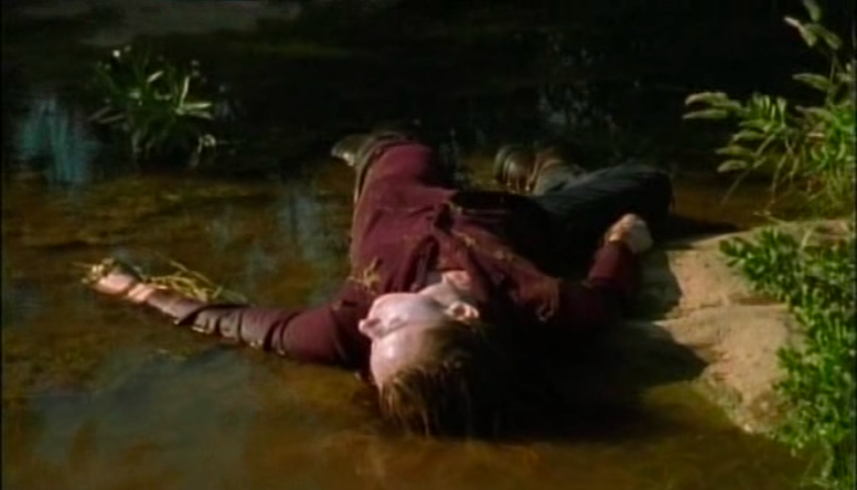 The dead body of a woman rests in a stream.