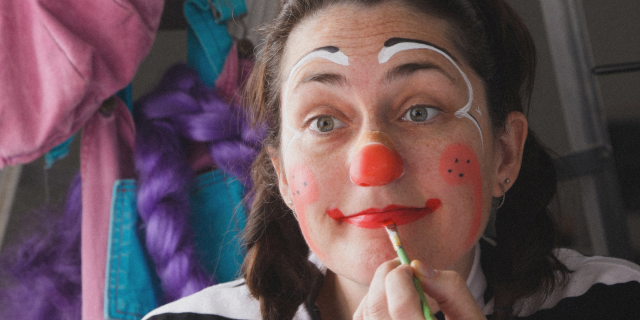 A clown painting their face