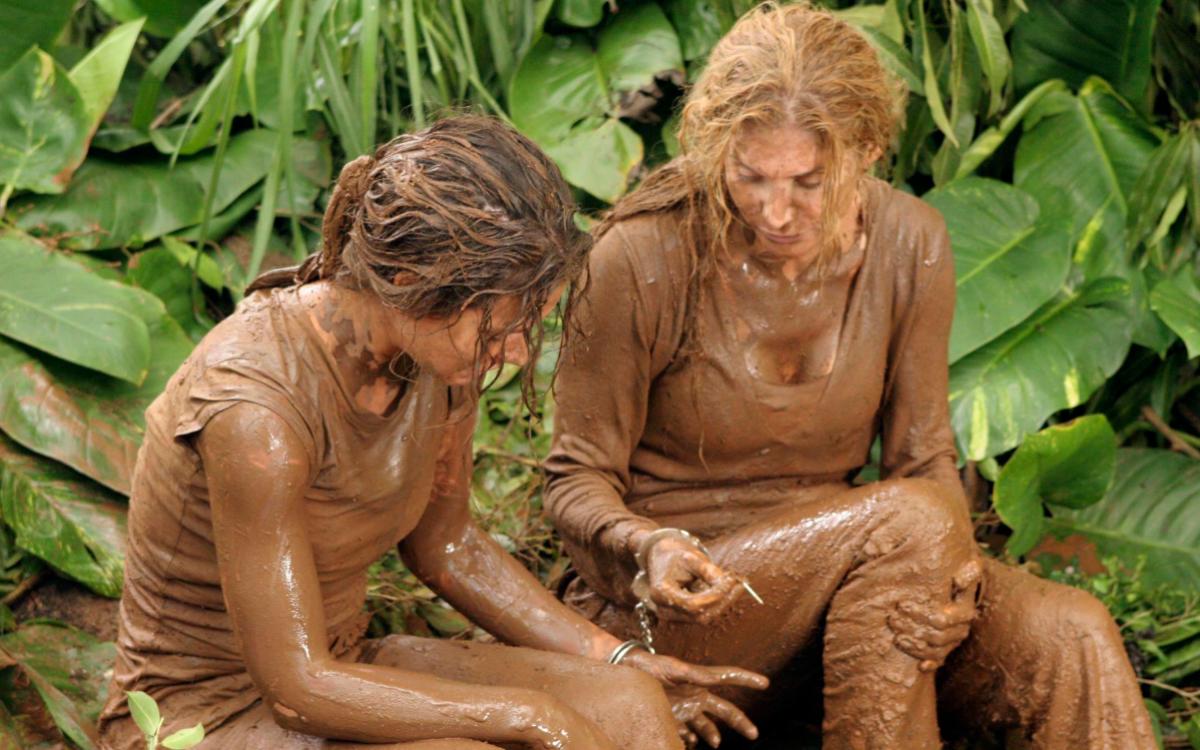 Kate and Juliet covered in mud handcuffed together.
