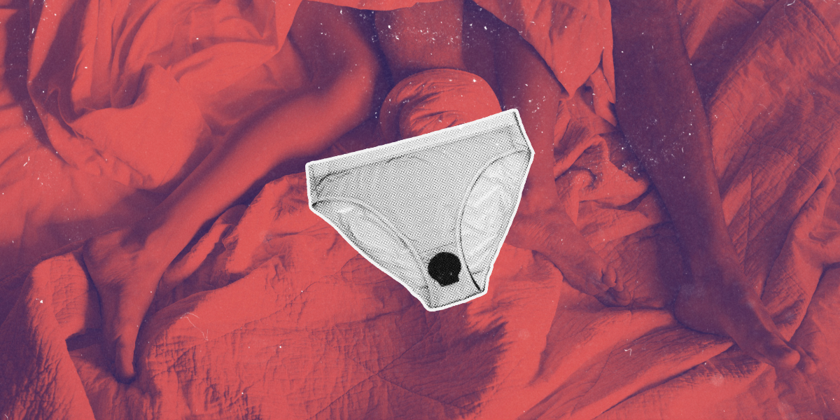a white pair of brief style underwear stands out against a background of red sheets. a dark black spot stands out in the gusset of the underwear