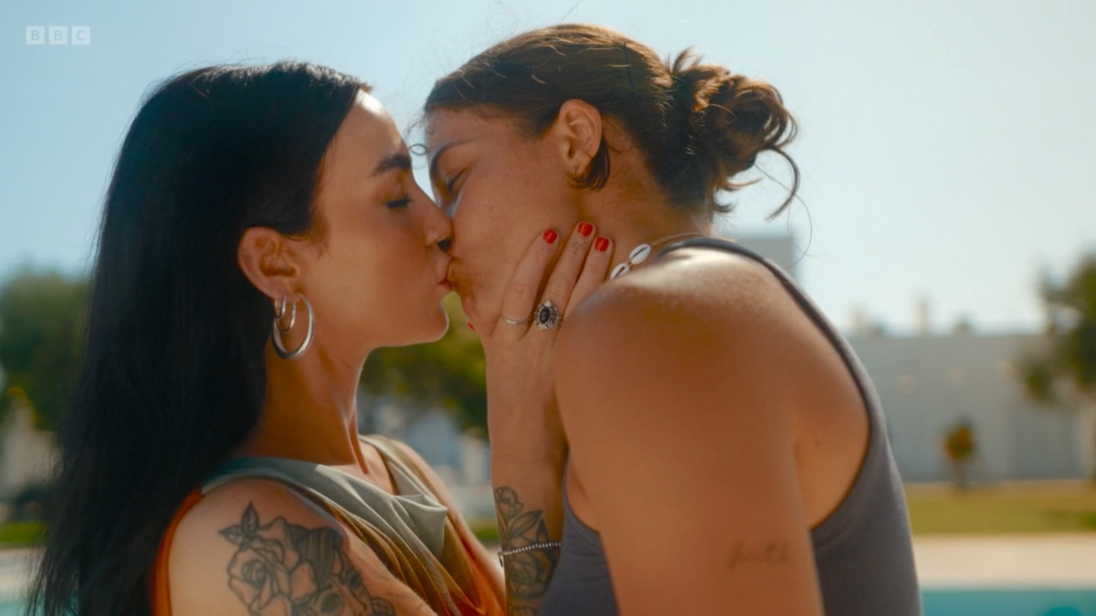 Cara, a tattoo-laden Northern Irish femme, and Georgia, a football player with swagger, kiss.