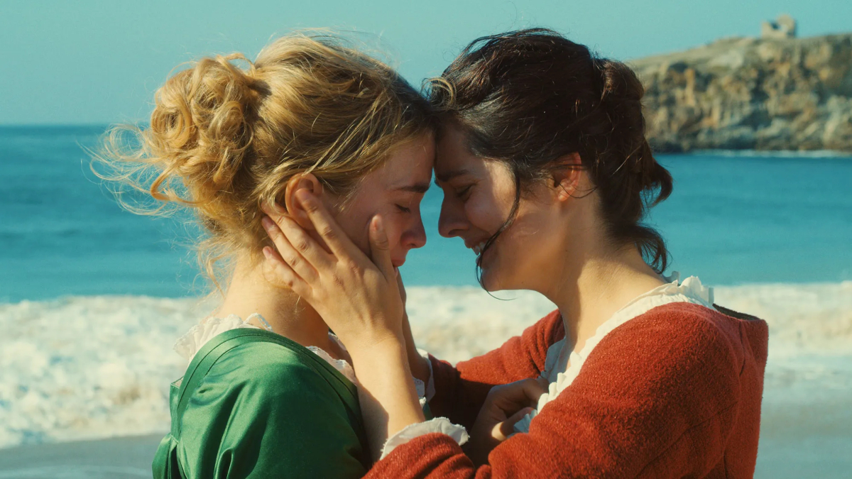 Cannes lesbian movies: Adèle Haenel and Noémie Merlant cry by the sea with their heads together and Merlant's hands on Haenel's face.