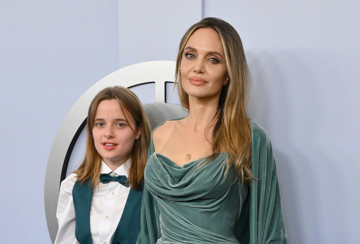 Angelina Jolie and her daughter Vivienne walking the red carpet at the Tony Awards, Angelina in a teal dress and Vivienne in a teal vest and bow tie combo