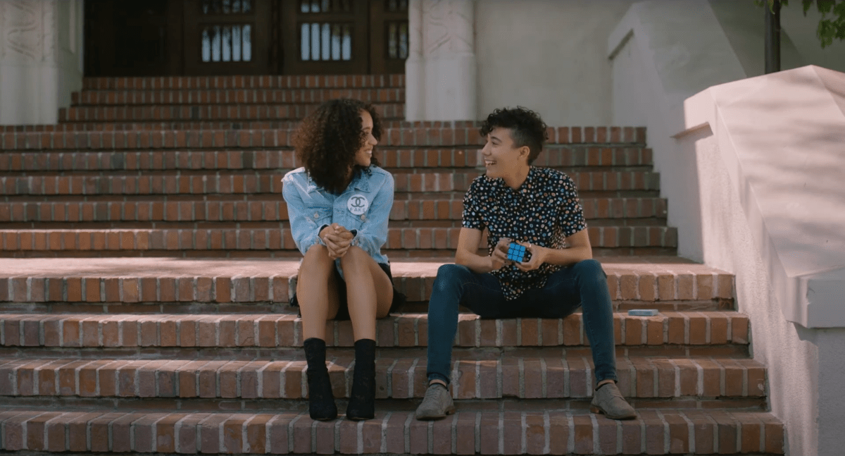 Jasmin Savoy Brown and Vico Ortiz talk while sitting on some stairs.