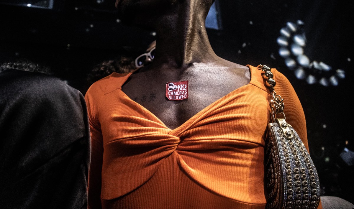 someone wears a sticker saying NO CAMERAS ALLOWED