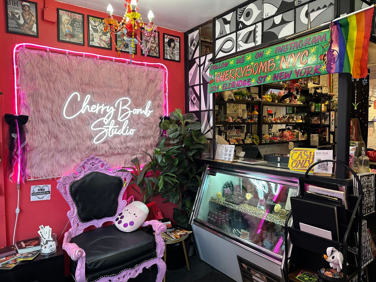 Cherry Bomb Studio's front desk with purples and pinks and a visible Pride flag.