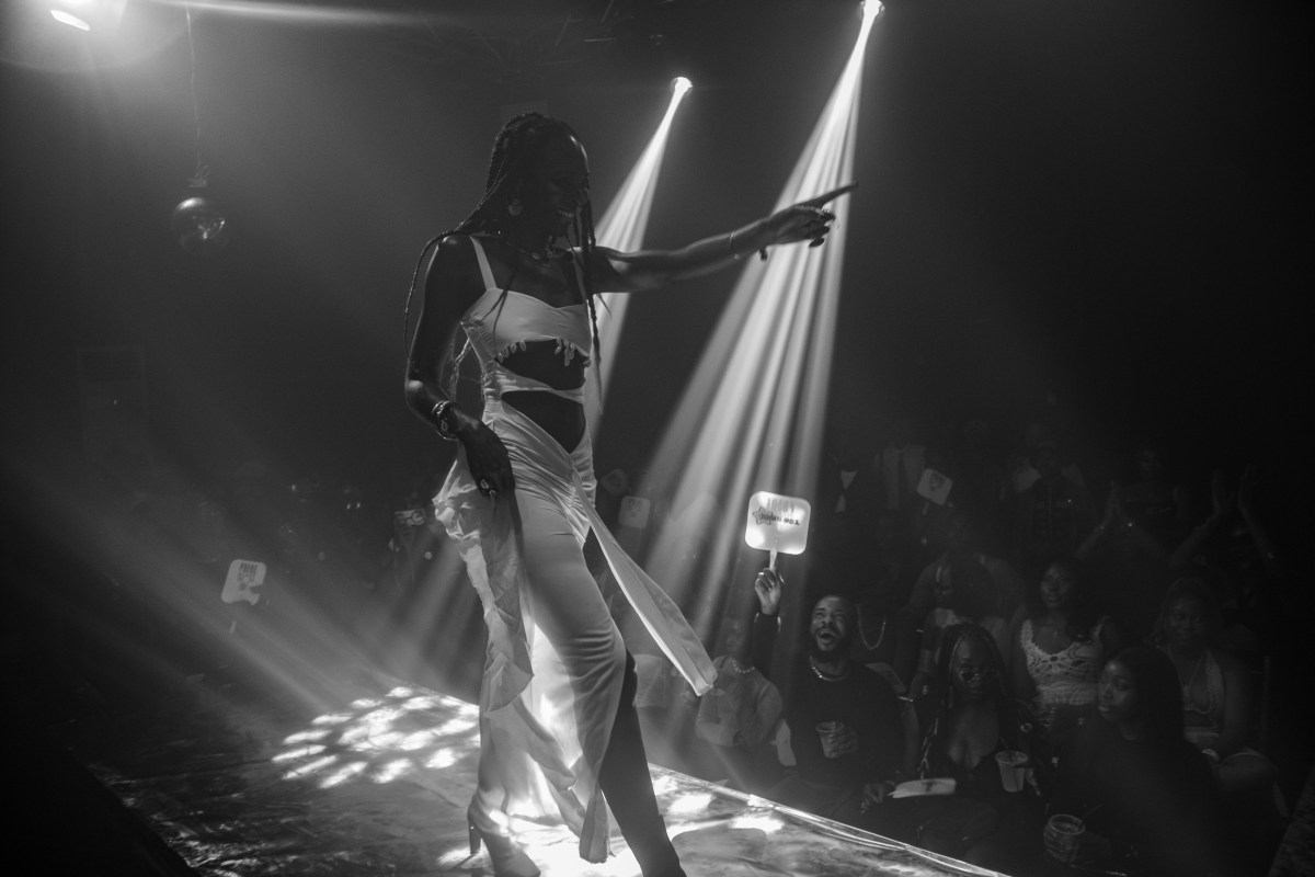 a ballroom performer points out at attendees