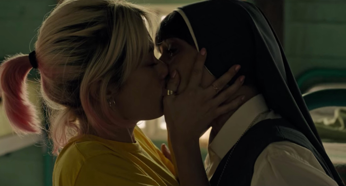 A girl with blonde and pink dyed hair kisses a nun