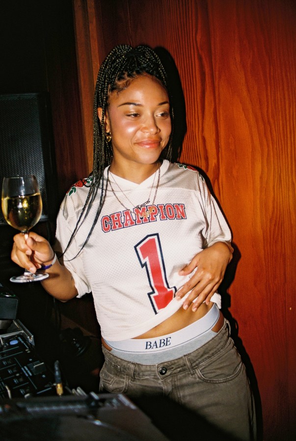 a person holds a glass of wine while showing off BABE underwear