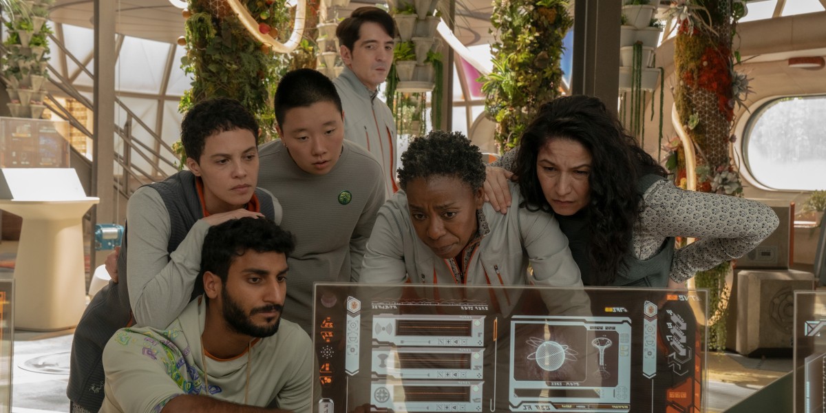Murderbot: The cast of queer humans huddles around a futuristic looking computer screen