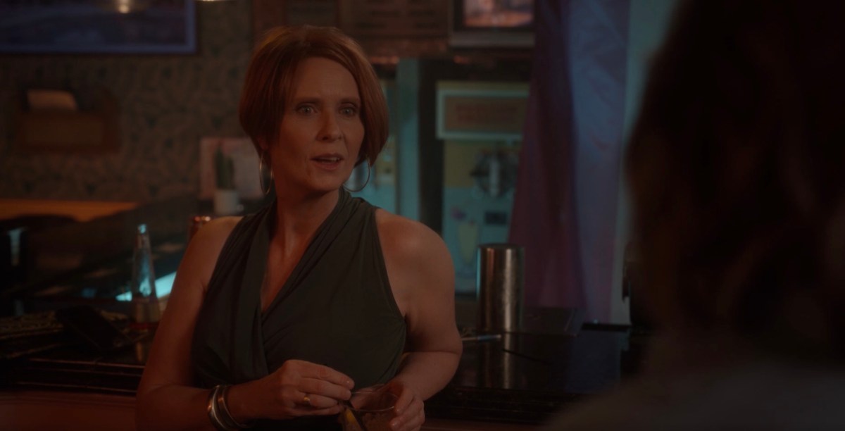 Miranda leaning on the bar in a green top