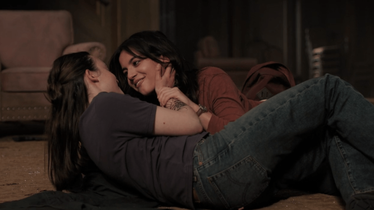 The Last of Us 204: Ellie and Dina smile tangled up in each other on the floor