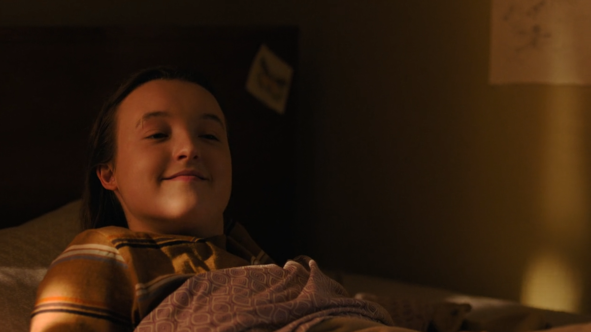 The Last of Us 205: Ellie smiles a soft, sleepy smile up at Joel