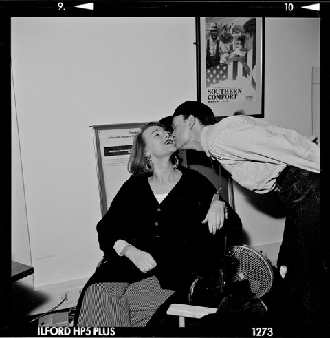 A black and white photo from the 90s of someone kissing Kristiene Clarke on the cheek