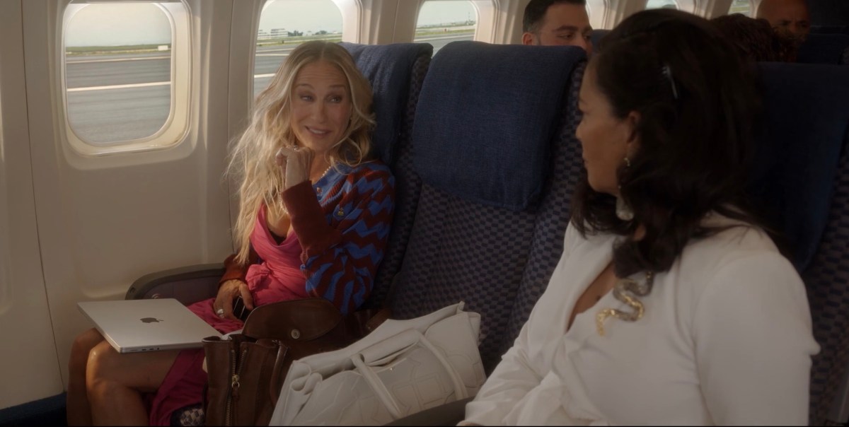 Carrie talking to Seema on the plane