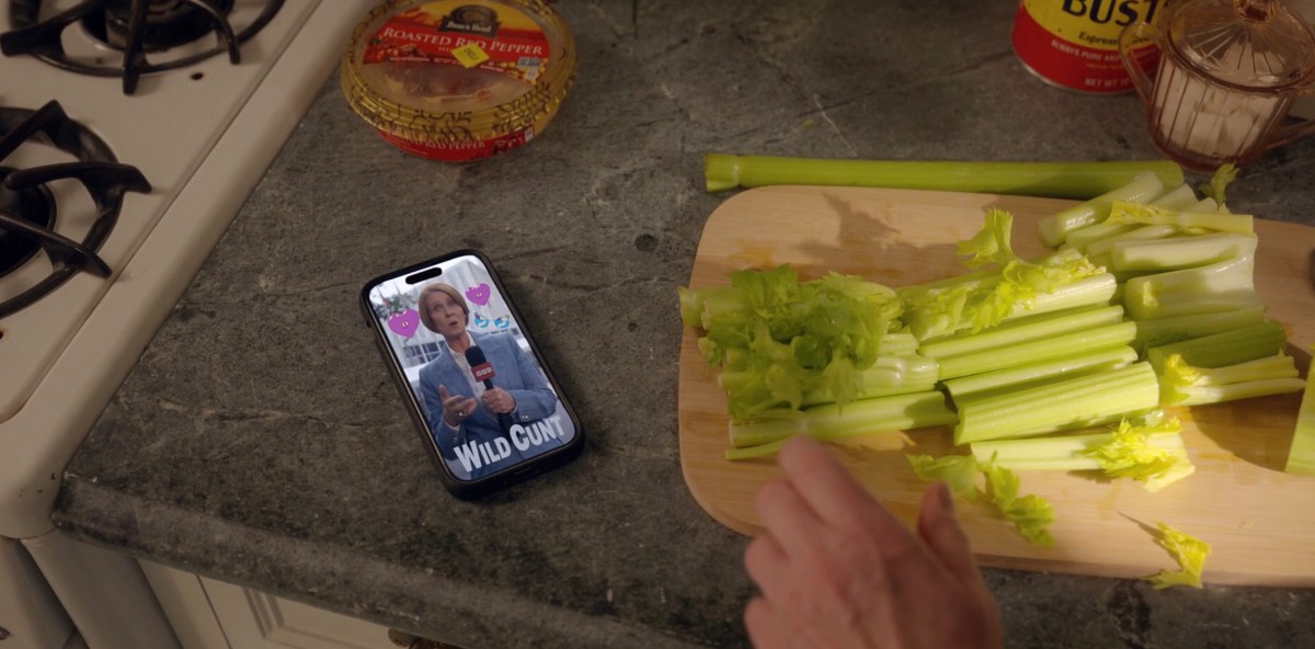 a phone with the WILD CUNT meme on it next to the celebry