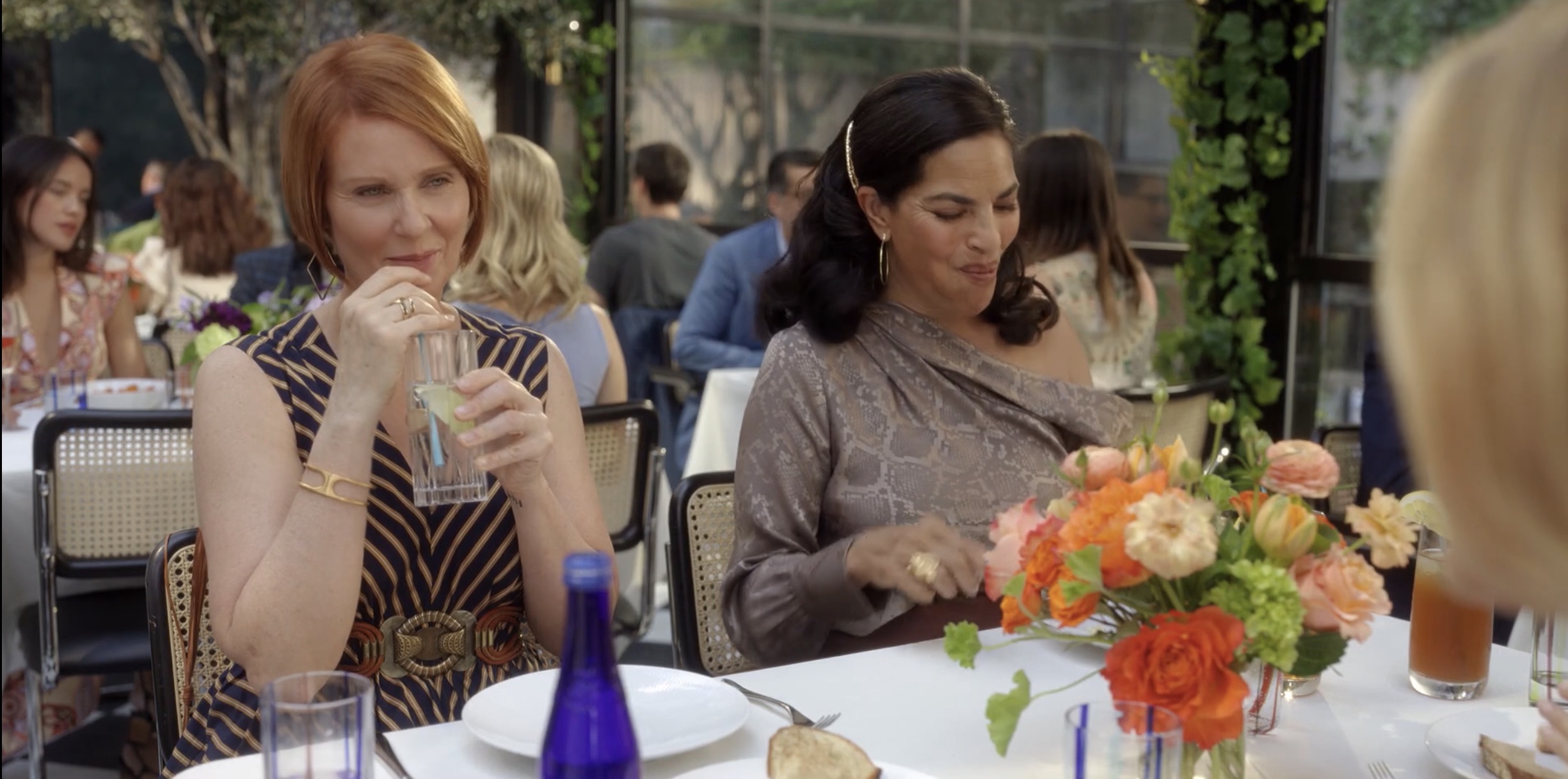 Miranda sucking on her straw while Seems looks at her purse