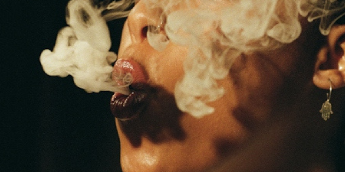 a pesron blowing a puff of smoke