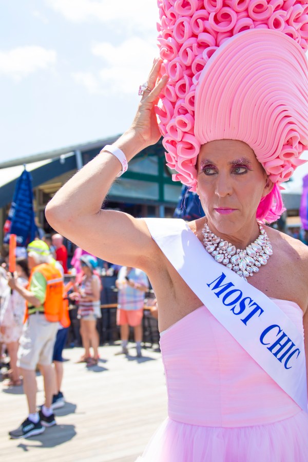 a drag queen with a MOST CHIC sash poses