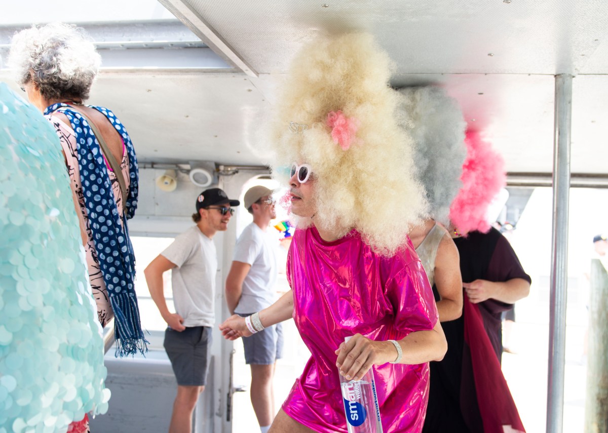drag queens in giant wigs boarding a ferry