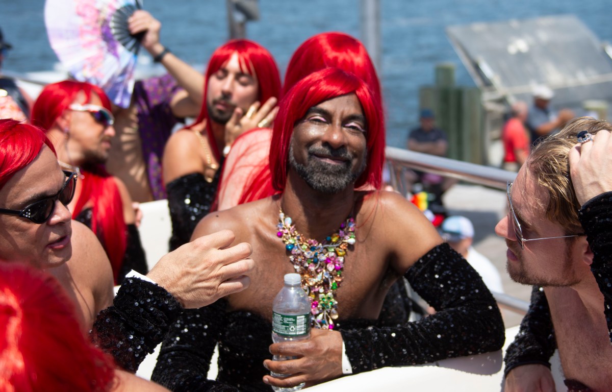 attendees of the 50th invasion of the pines wear red wigs on the ferry
