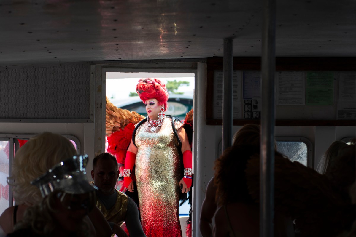 a drag queen boards the ferry for the 50th invasion of the pines