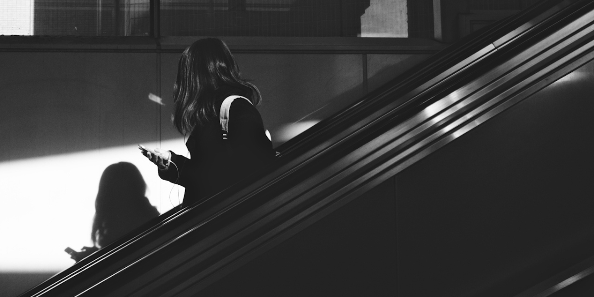 a person looking at their phone in black and white