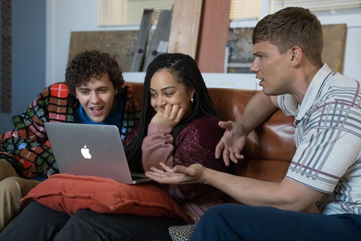 three young people sitting on a couch looking at a laptop on "big boys"