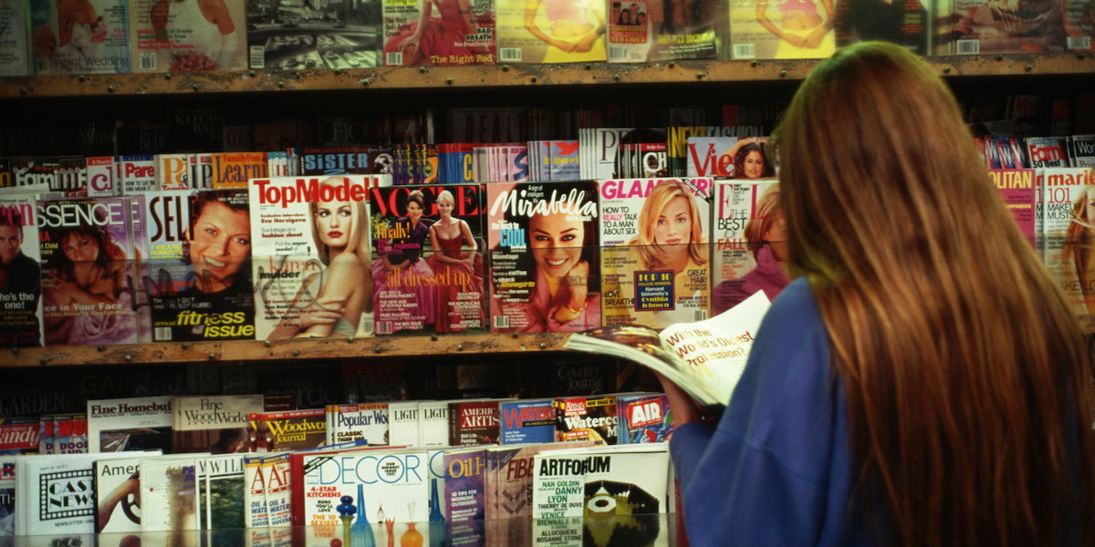 woman looking at magazines at a magazine rack