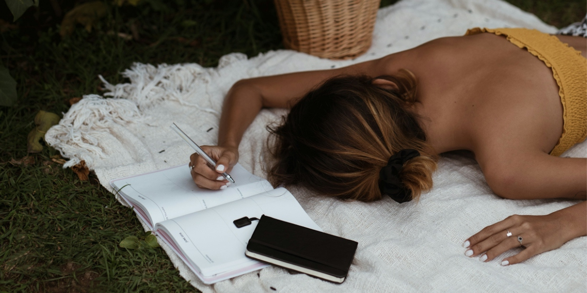 a person face down writing in a planner