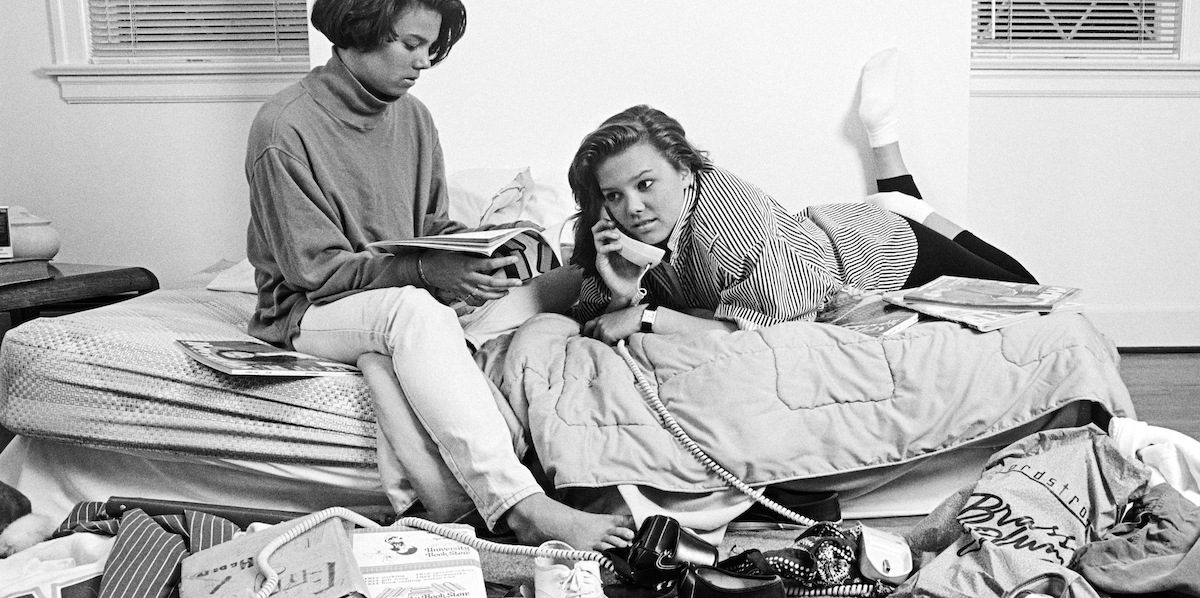 1980s TWO TEENAGE AFRICAN AMERICAN GIRLS IN CLUTTERED BEDROOM ONE TALKING ON THE PHONE ONE READING MAGAZINE (Photo by H. Armstrong Roberts/ClassicStock/Getty Images)