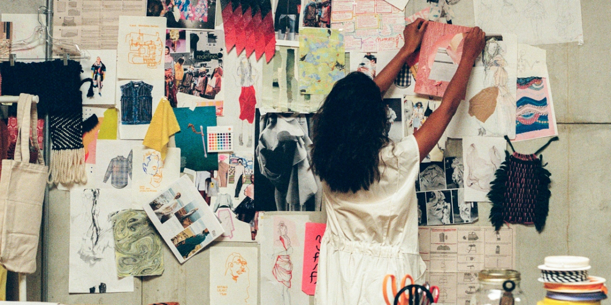 a person putting up photos on a mood board