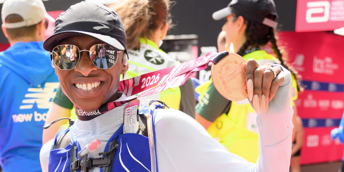 Cynthia Erivo poses post-marathon, holding the medal around her neck out, smiling wide